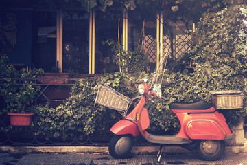 retro scooter in italy, traditional style motorcycle with foliage background (image with vintage effect)