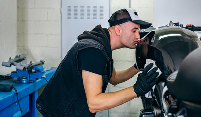 Wall Mural - Mechanic kissing the motorbike while cleaning it in the workshop