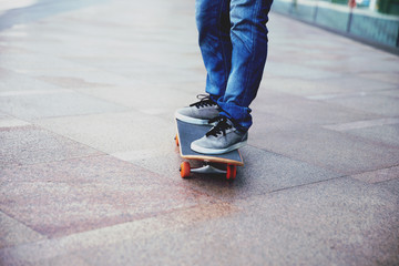 Wall Mural - Skateboarder legs riding skateboard on city street