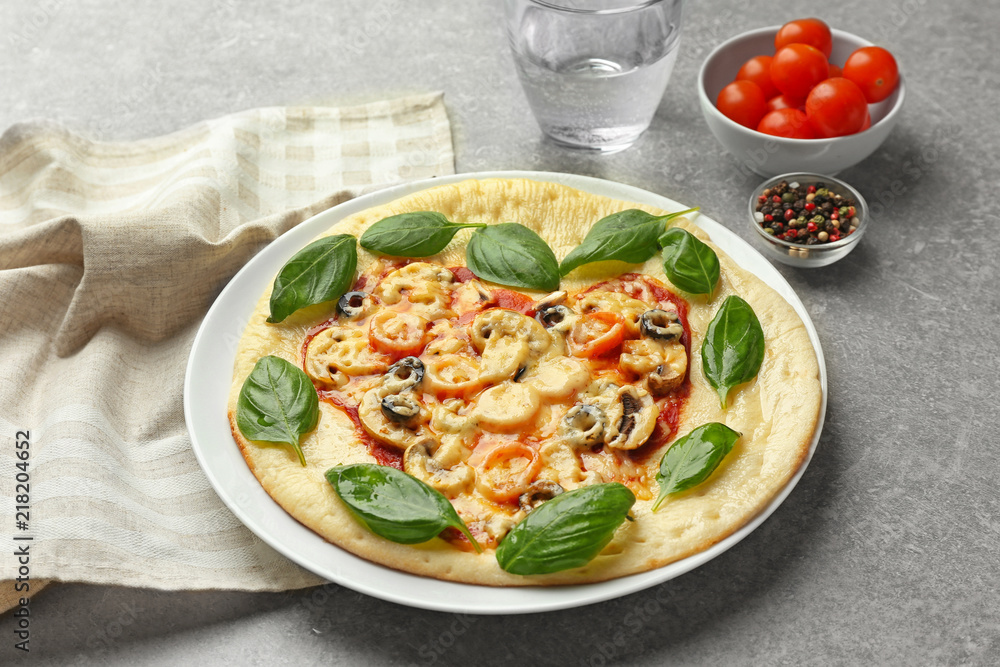 Plate with tasty pizza on grey table