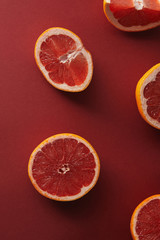 elevated view of cut grapefruits on red surface