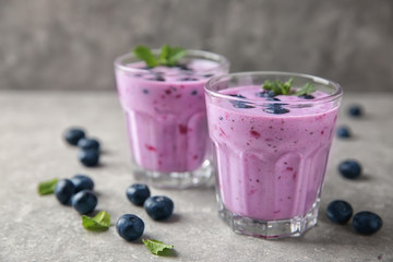 Wall Mural - Glasses of tasty blueberry smoothie on light table