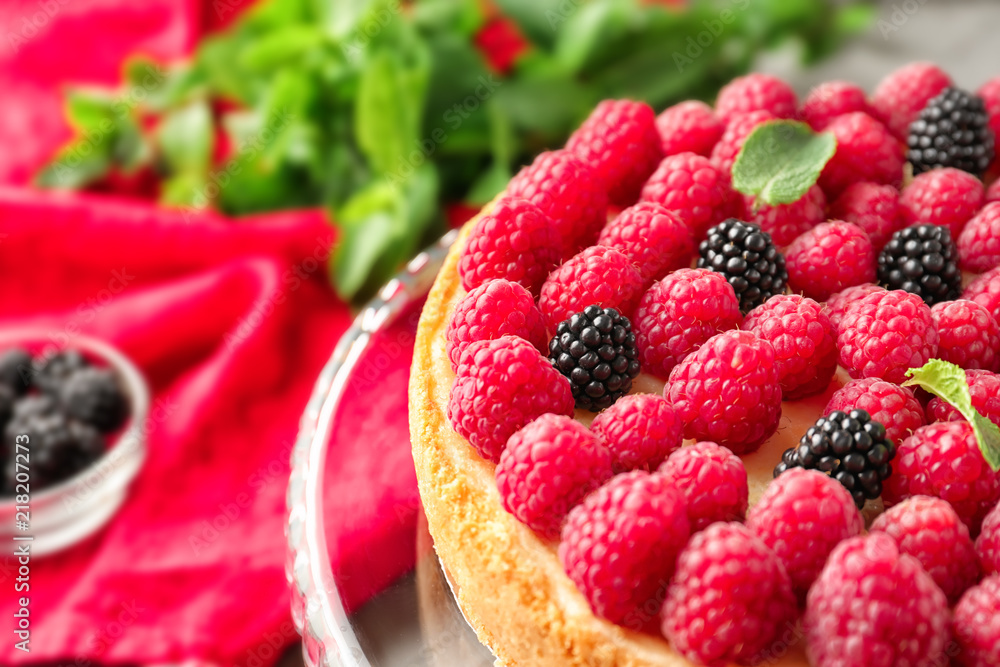 Delicious cheesecake with raspberries on stand, closeup