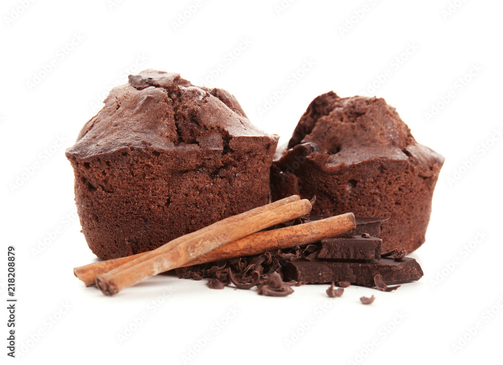 Sweet tasty muffins with cinnamon sticks and chocolate on white background