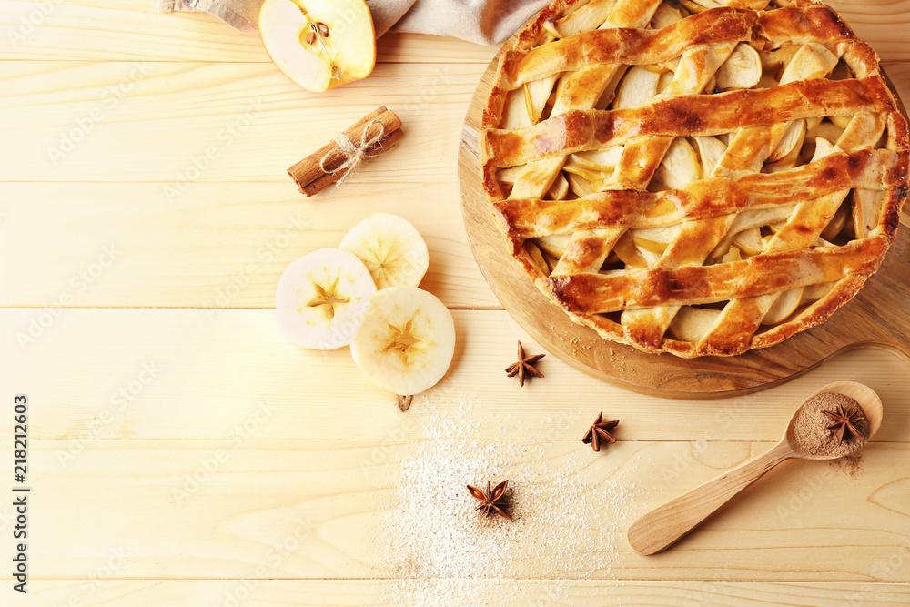 Board with delicious apple pie on wooden table