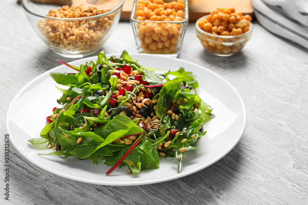 Plate with healthy fresh salad on white wooden table