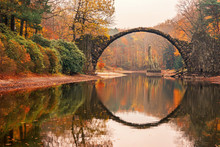 Rakotz Bridge (Rakotzbrucke, Devil's Bridge) In Kromlau, Saxony, Germany. Colorful Autumn, Reflection Of The Bridge In The Water Create A Full Circle.Unusual And Interesting Places In Germany.