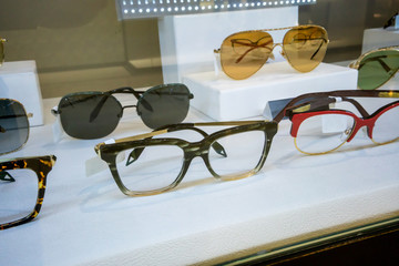 Various of colorful sun glasses in the shop display shelves.