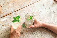 Two Drinks In Glasses With White Straws And Mint