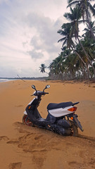 Wall Mural - Moped on a tropical beach with palm trees