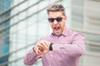 © zphoto83 - Shocked business person while checking time on his watch outdoors.