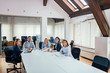 © bnenin - Smiling corporate business team sitting in the boardroom. Copy space.