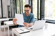 © bnenin - Handsome young man looking at paper documents with good results and smiling.