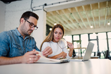 Two concentrated business colleagues working in bright office.