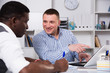 © JackF - Smiling business partners with laptop in office