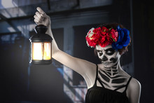 Halloween Witch. Beautiful Woman Wearing Santa Muerte Mask Casting Spell Near Light Bulb