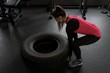 © Wavebreak Media - Woman exercising with tyre in fitness studio