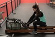 © Wavebreak Media - Woman using rowing machine in fitness studio
