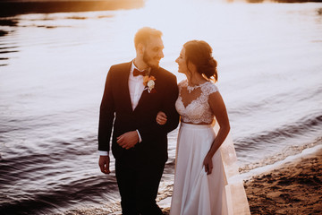 Sea travel, couple in love hugging near sea with orange sunset. Love and adventure at sea side.