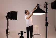 Male Photographer Adjusting Strobe Lights