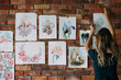 © golubovy - art studio workspace. painter artwork. woman sticking watercolor drawings of flowers and animals to the wall