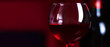 Wine. A glass and a bottle of red wine.. Red wine on a dark background.