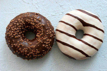 Two chocolate-coated doughnuts in close-up, sweet dessert.