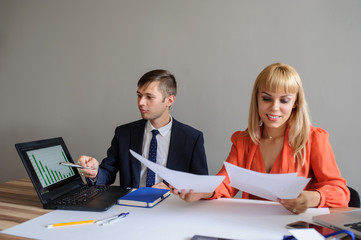 A business woman and man at a office desk  working at the projec