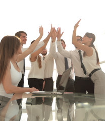 Portrait of a cheerful business team joining hands together in bright office