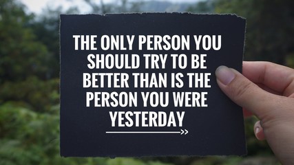 Wall Mural - Inspirational and motivational quote - ‘The only person you should try to be better than is the person you were yesterday’ written on a black paper. Vintage styled blurry background.