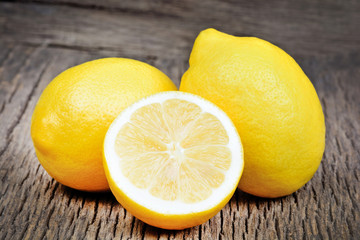 Sticker - Lemons and half on a rustic wood background