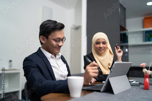 Fotografía asian malay couple working together at home with laptop and calculator