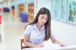 © teerapong - Beautiful women asian university student in library.