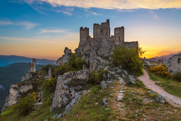 Rocca Calascio (Italy) - The ruins of an old medieval village with castle and church, over 1400 meters above sea level on the Apennine mountains in the heart of Abruzzo, at sunset.