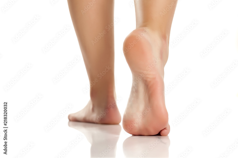 female bare feet on white background - obrazy, fototapety, plakaty 