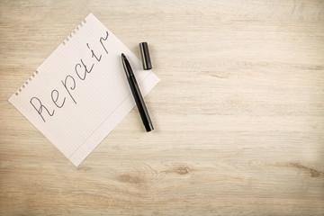 Wall Mural - inscription repair on a sheet of paper lies on a wooden background