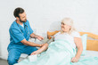© LIGHTFIELD STUDIOS - young social worker measuring blood pressure to senior woman lying in bed