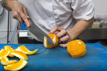 Chief cut orange fruits on chopping board