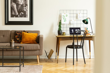 Wall Mural - Vintage sofa next to a simple desk and chair in a living room interior. Real photo