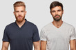 © wayhome.studio  - Two bearded brothers in casual t shirts, have serious expressions, stand next to each other, isolated over white background. Handsome ginger hipster guy and his companion think about something