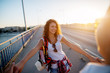 © dusanpetkovic1 - Curly happy beautiful girl is holding hands with her boyfriend while they enjoy sunset on a bridge.