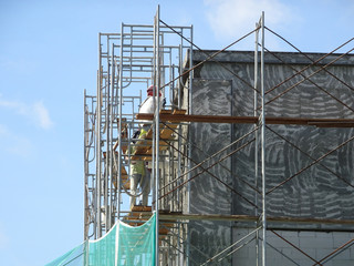 Wall Mural - Construction workers plastering wall using cement plaster at the construction site. They are wearing appropriate safety gear to prevent bad happen.  