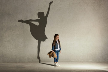 baby girl dreaming about dancing ballet. childhood and dream concept. conceptual image with shadow o