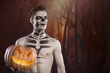 Man In Scary Halloween Make Up Holding Pumpkin