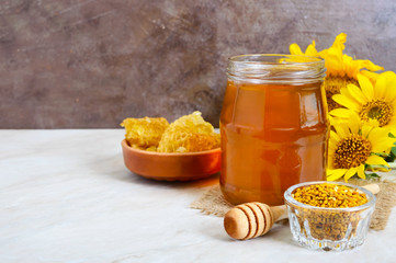 Wall Mural - Honey in a glass jar, honeycomb, pollen. Products of beekeeping. The concept of healthy eating.