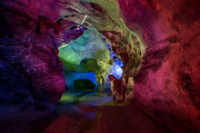 Abstract Cave Interior Chamber Photograph - Colored Lights, Bumpy Rock Surfaces And Exotic Rock Formations. Textures, Rugged Surface, Underground Exploration. Alien Planet Concept, Cave Geology.