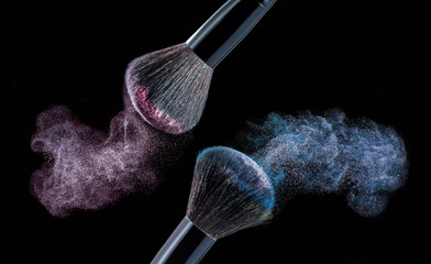 Make up brush with powder splashes on black background