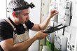 © pavelgulea - Electrician testing equipment in fuse switch box close up