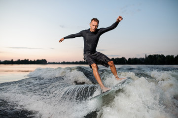 Wall Mural - Young wakesurfer jumping on a wake board down the river