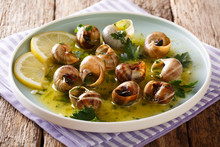 Delicatessen Food: Edible Snails, Escargot Cooked With Butter, Parsley, Lemon And Garlic Close-up On The Table. Horizontal
